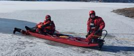 Strażacy za pomocą sań lodowych poruszają się po zamarzniętym akwenie