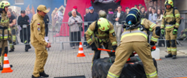 Strażacy OSP biorą udział w konkurencji podczas zawodów firefighter przed zgromadzoną publicznością.