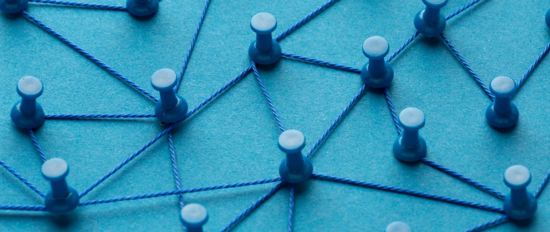 Sieć przedstawiona za pomocą pinezek i sznurka