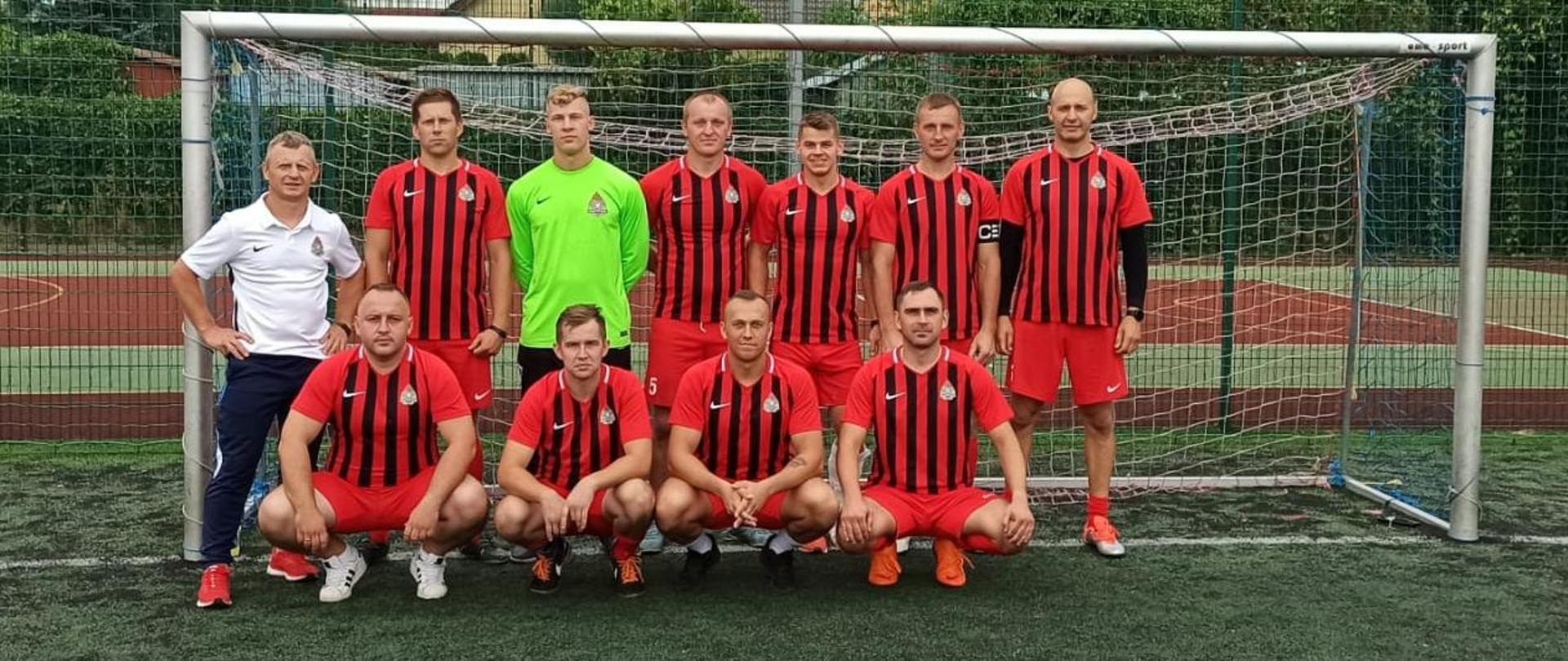 Eliminacje strefowe do I Mistrzostwa Województwa Mazowieckiego strażaków w piłce nożnej 6 osobowej.- na zdjęciu drużyna w strojach sportowych na zbiórce w bramce na boisku orlik