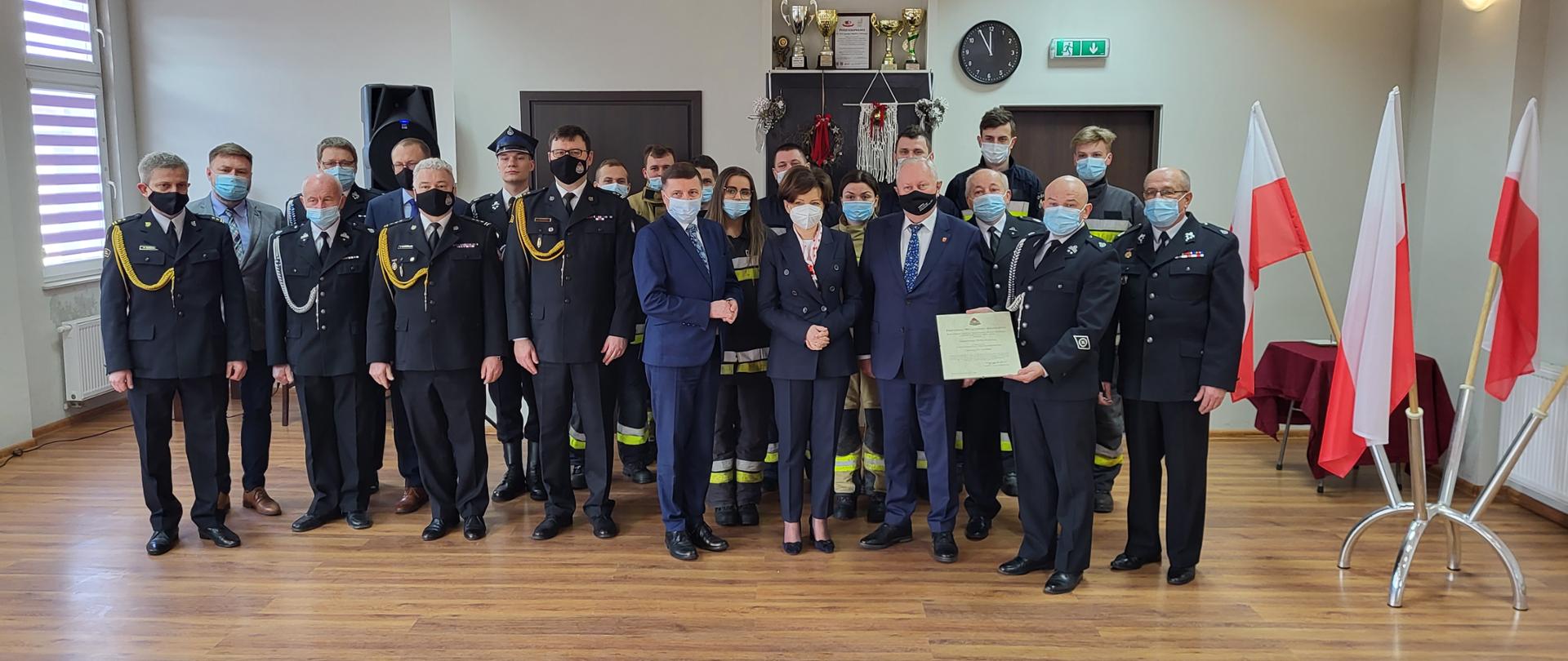 zdjecie grupowe strażaków PSP i OSP oraz osób cywilnmych, osoby są w maseczkach ochronnych 