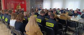 19 lutego 2026 r. w siedzibie Komendy Powiatowej Państwowej Straży Pożarnej w Siemiatyczach odbyła się coroczna odprawa podsumowująca stan bezpieczeństwa pożarowego na terenie powiatu siemiatyckiego w 2025 roku - sala pełna zaproszonych gości i funkcjonariuszy, przy mównicy stoi komendant powiatowy