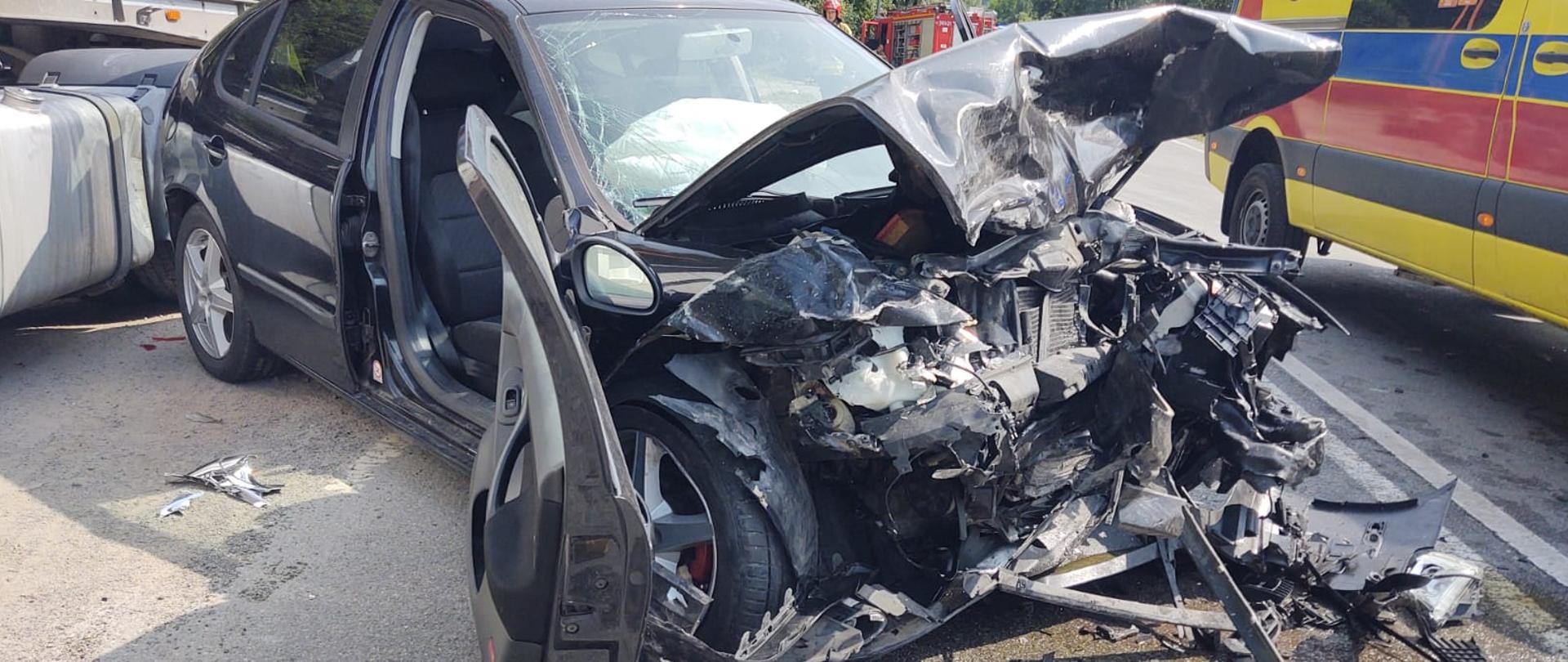 Rozbity samochód osobowy obok samochodu ciężarowego.