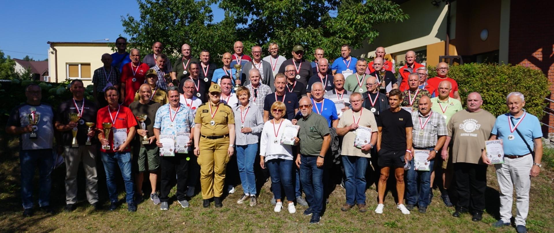 zdjęcie grupowe zawodników turnieju , w tle drzewa i budynki