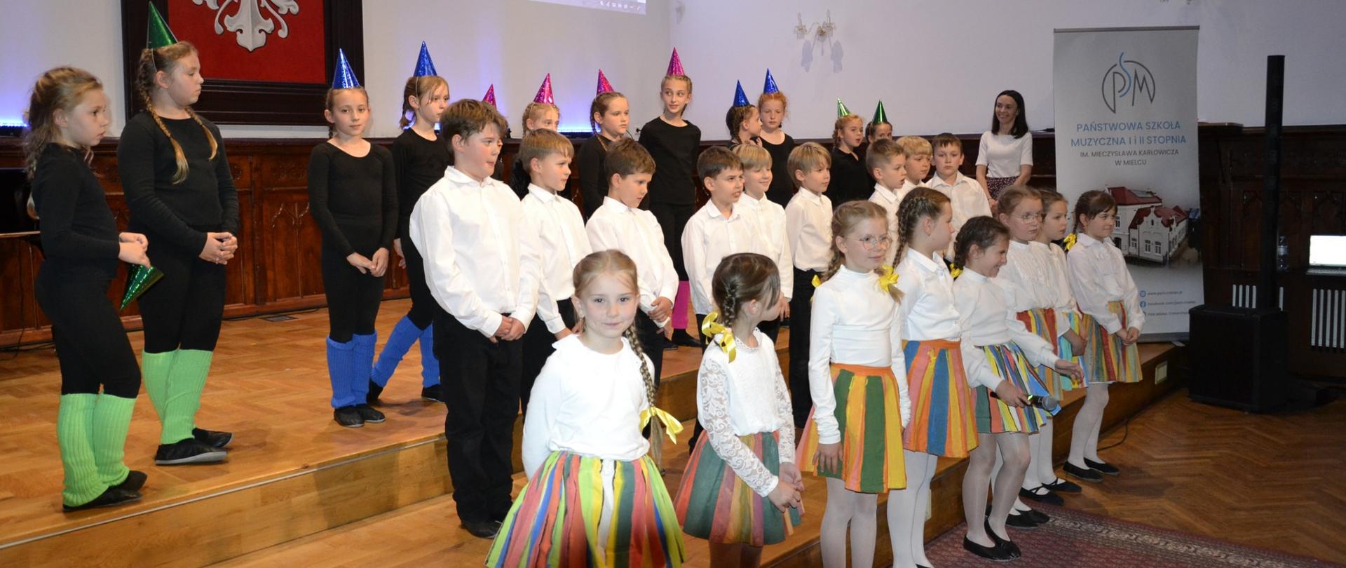 Uczniowie występujący na koncercie z okazji Dnia Matki na scenie w sali królewskiej PSM Mielec