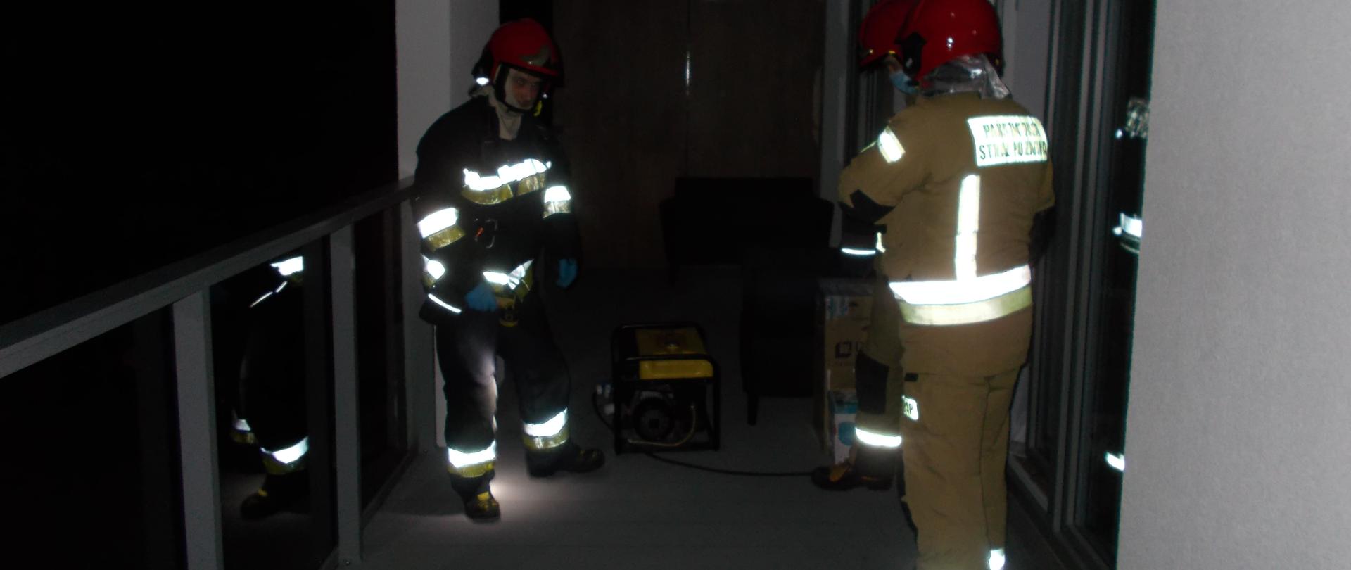 Działania związane z przerwą w dostawie energii elektrycznej. Strażacy podłączają agregat prądotwórczy.