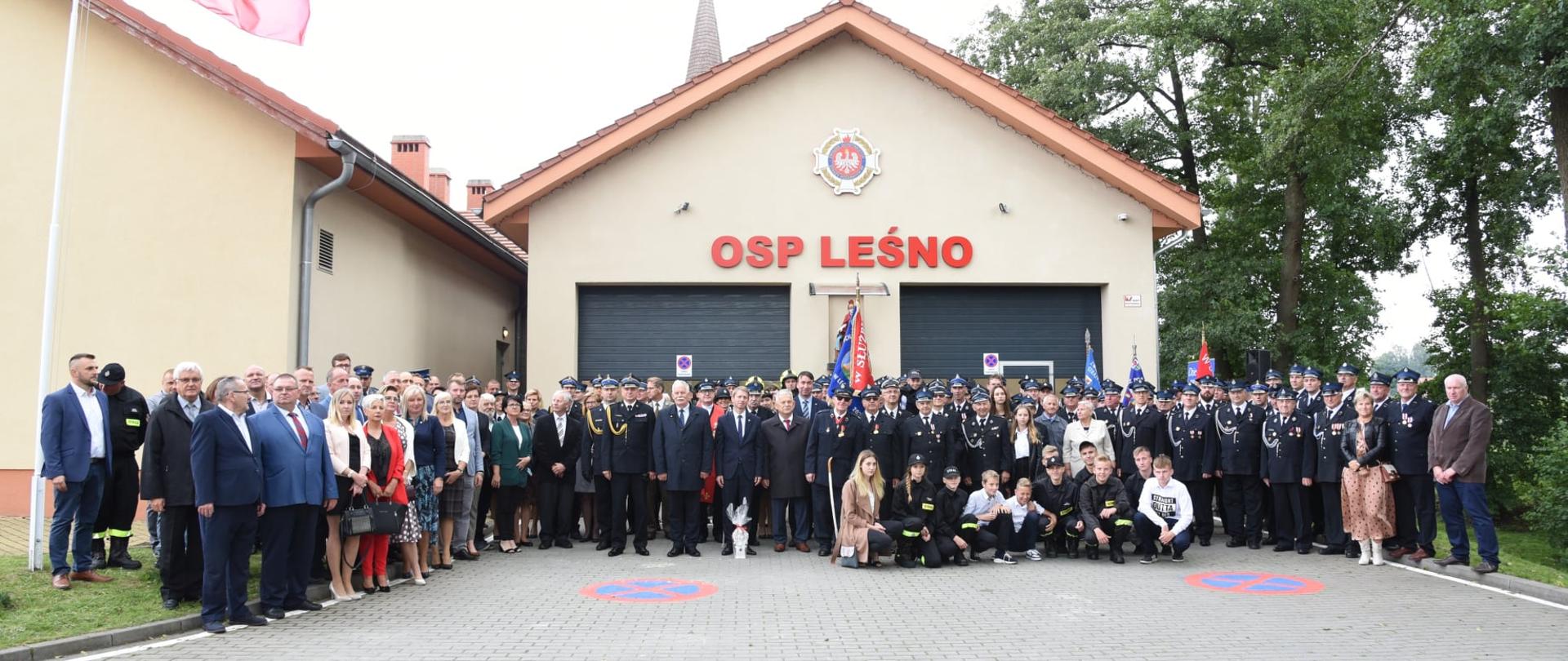 Uczestniczy uroczystość stoją przed remizą OSP Leśno.
