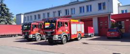 Pojazdy strażackie przed budynkiem komendy, miejsce zbiórki