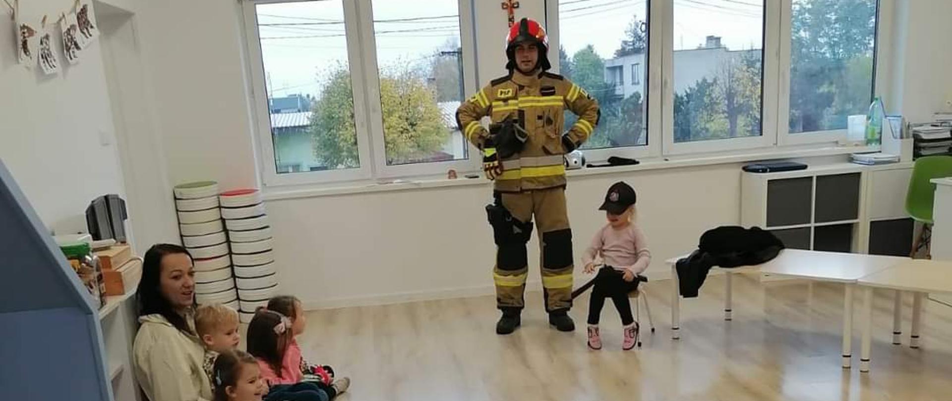 Zdjęcie przedstawia strażaka PSP podczas zajęć z przedszkolakami z Osięcin