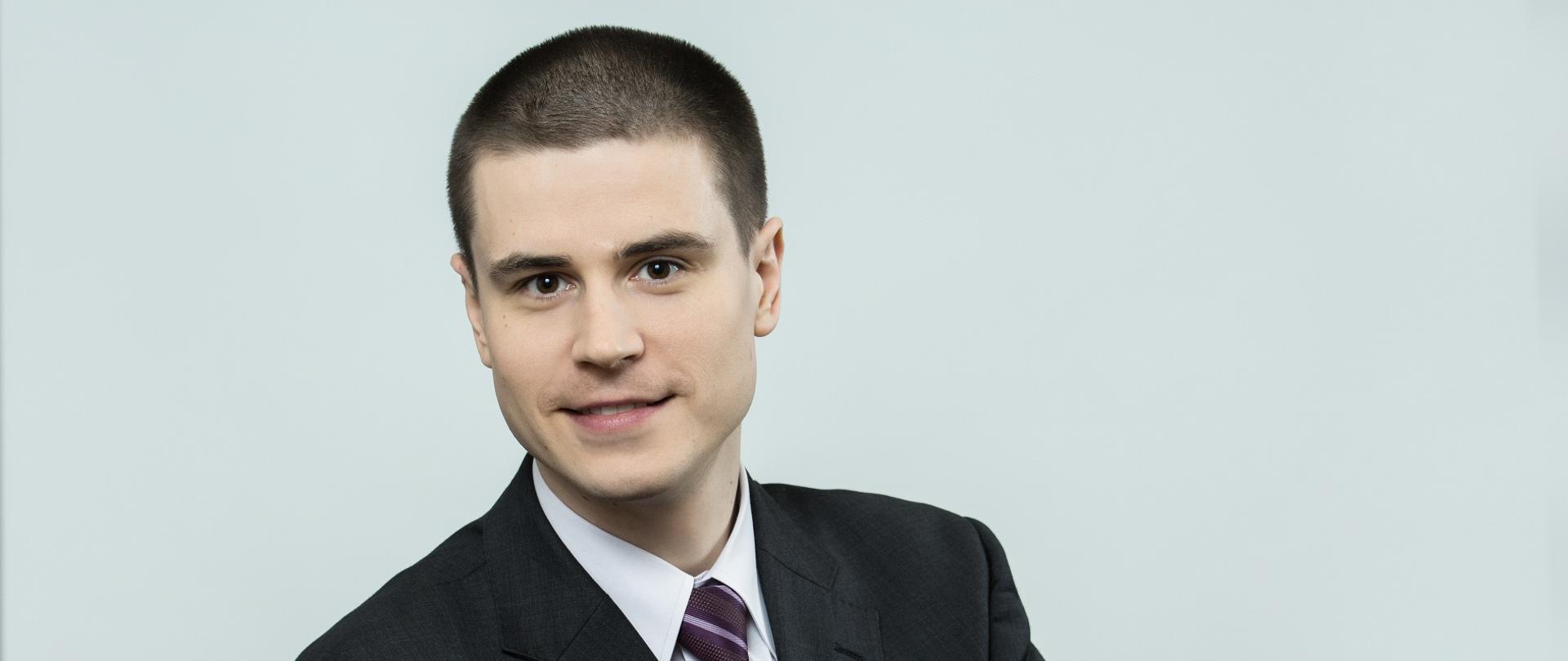 Mężczyzna ubrany w garnitur ze skrzyżowanymi rękami