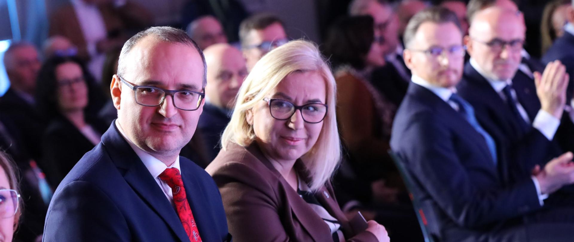 dwie osoby siedza w sali i obserwują scenę