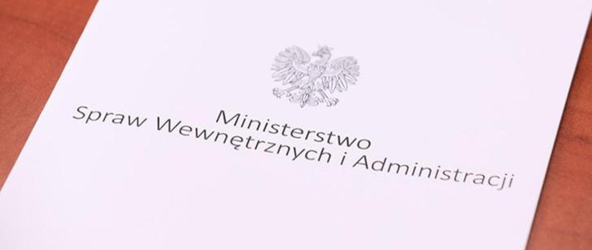 Zdjęcie przedstawia kartkę z nadrukowanym logo Ministerstwa Spraw Wewnętrznych i Administracji
