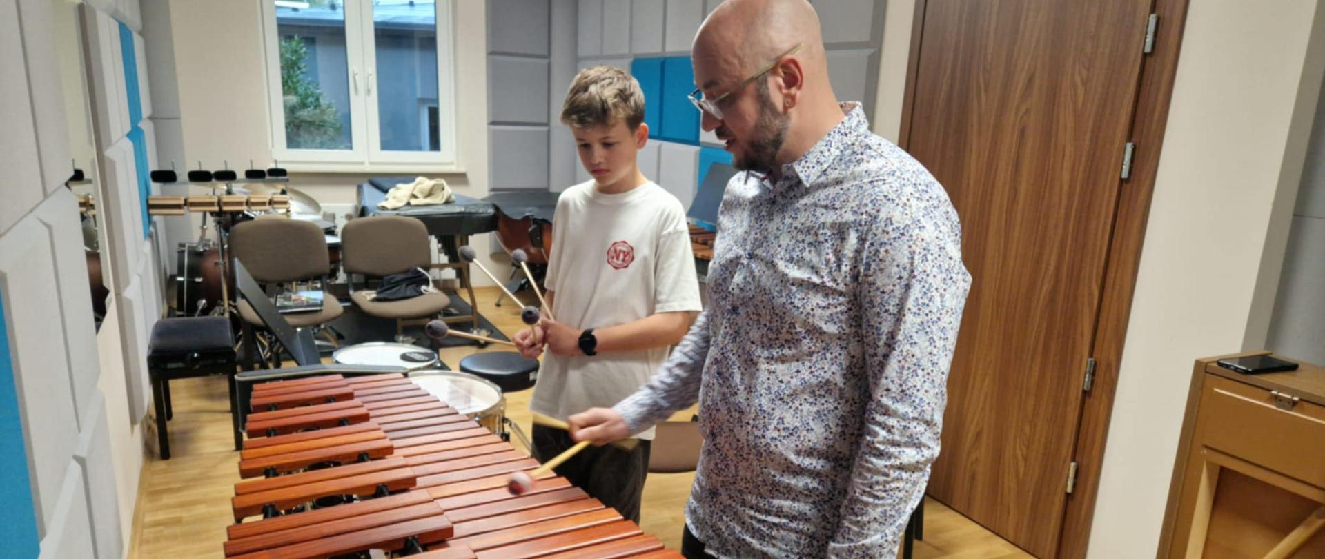Nauczyciel i uczeń stoją przy ksylofonie