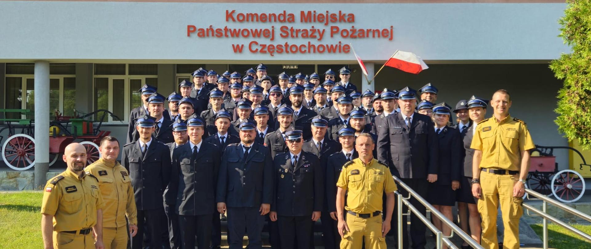 Strażacy Państwowej Straży Pożarnej i druhowie Ochotniczych Straży Pożarnych pozują do wspólnego zdjęcia przed budynkiem Komendy Miejskiej PSP w Częstochowie.