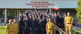 Strażacy Państwowej Straży Pożarnej i druhowie Ochotniczych Straży Pożarnych pozują do wspólnego zdjęcia przed budynkiem Komendy Miejskiej PSP w Częstochowie.