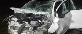 Wypadek na drodze wojewódzkiej nr 309. Zderzenie trzech pojazdów. Na pierwszym planie wrak toyoty, która ma bardzo mocno uszkodzony przód, w tym przednią szybę. Auto jest koloru białego.