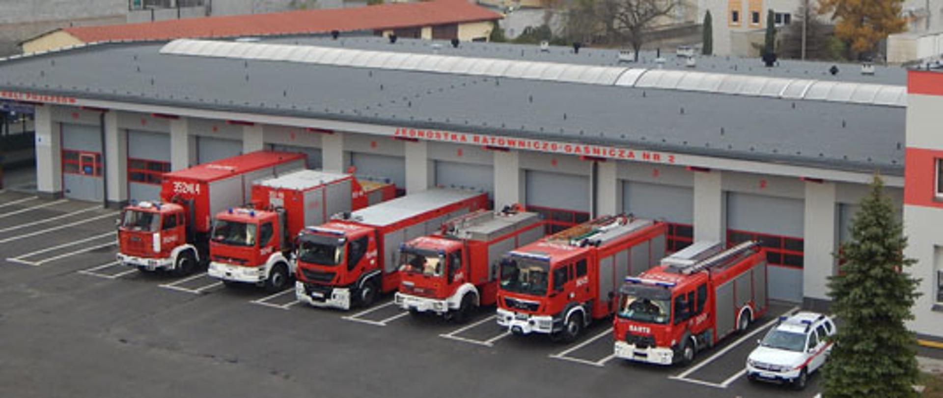 Zdjęcie przedstawia Jednostkę Ratowniczo Gaśniczą nr 2 w Częstochowie z lotu ptaka. Na zdjęciu widoczny obiekt Jednostki Ratowniczo Gaśniczej przed obiektem znajdują się pojazdy będące na wyposażeniu jednostki.