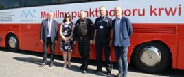 Na zdjęciu widzimy przedstawicieli instytucji współorganizujących zbiórkę na tle krwiobusa