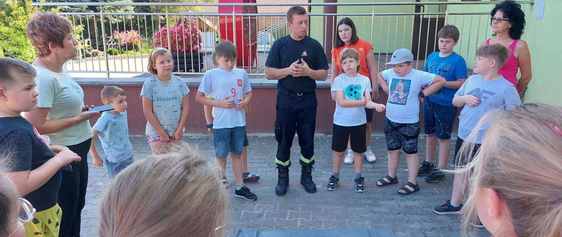 Strażacy podczas prelekcji z pierwszej pomocy medycznej na półkolonii dla dzieci i młodzieży.