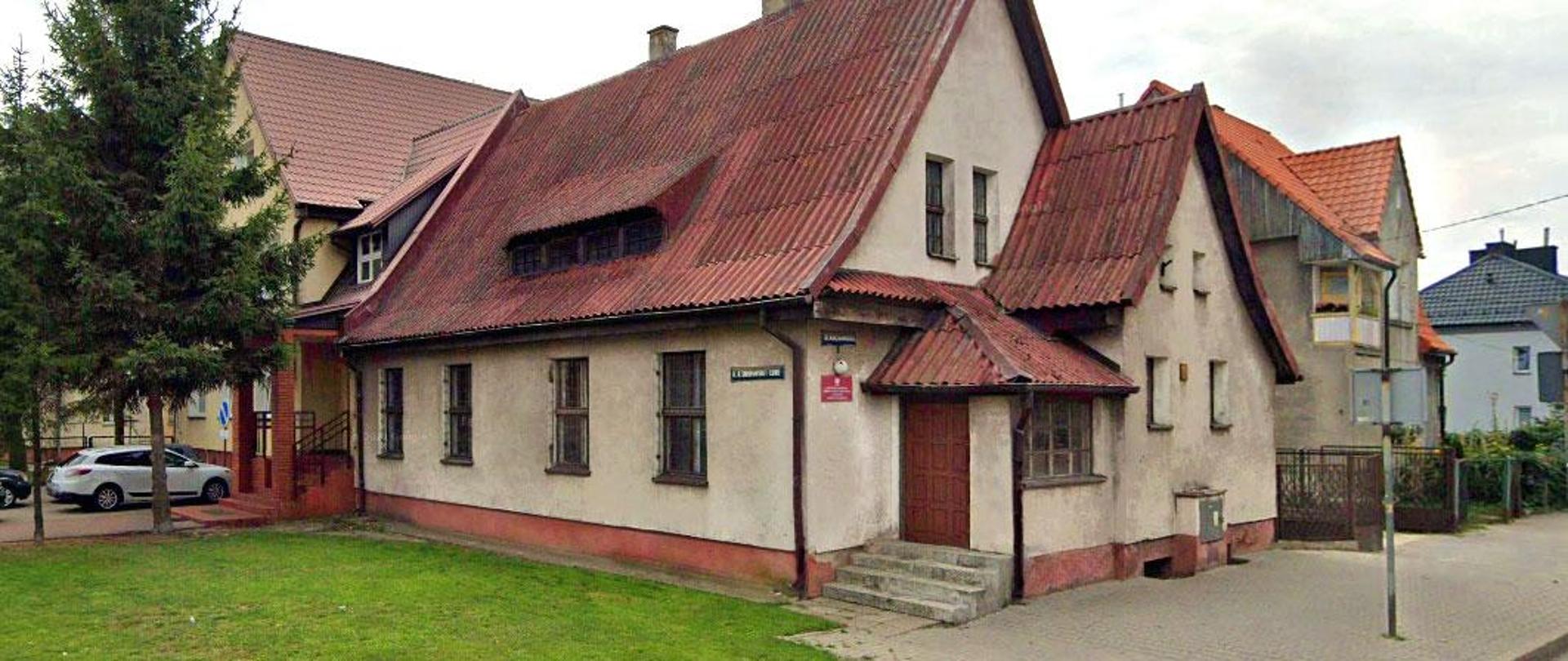 Zabytkowy budynek z czerwonym, spadzistym dachem
