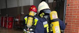 Szkolenie podstawowe OSP zdjęcie przedstawia strażaków ubranych w ODO wchodzących do pomieszczenia. 