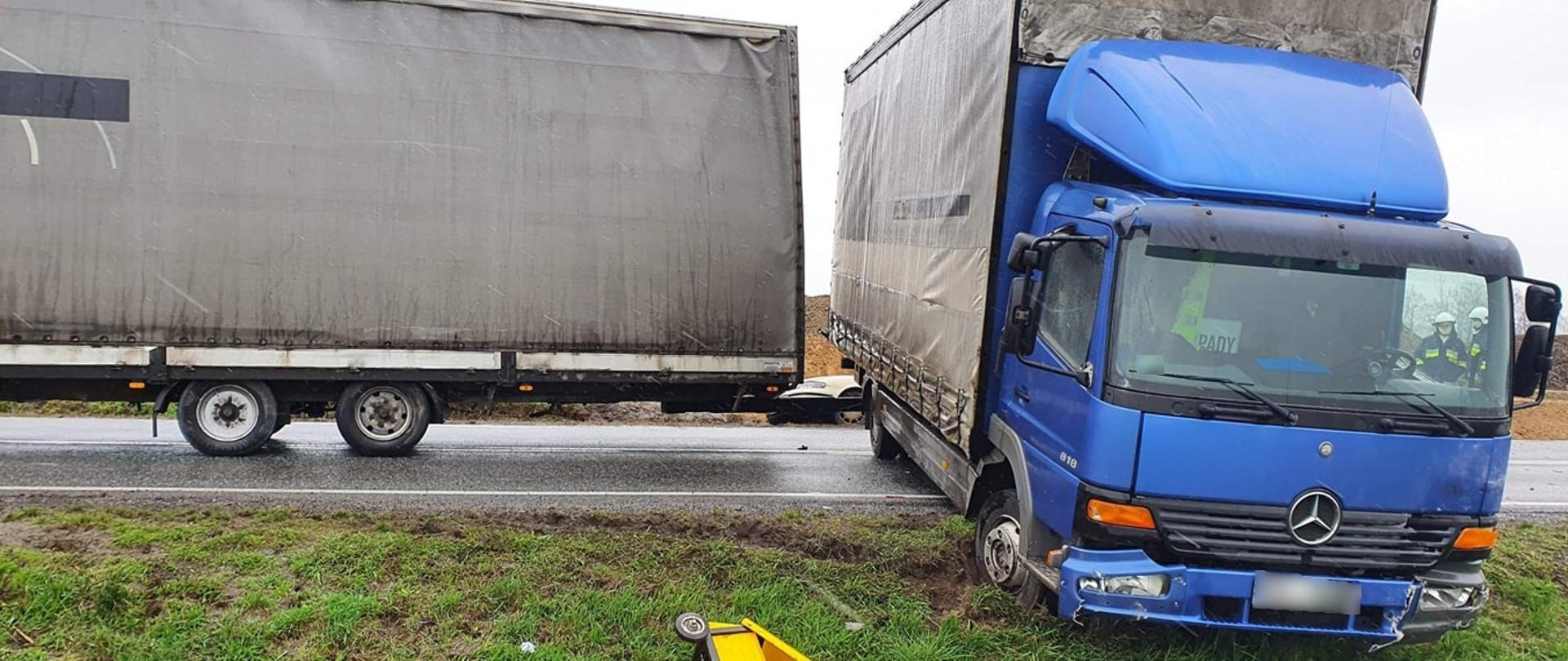 Miejsce zdarzenia widoczne pojazdu biorące udział w kolizji oraz strażacy działający na miejscu zdarzenia