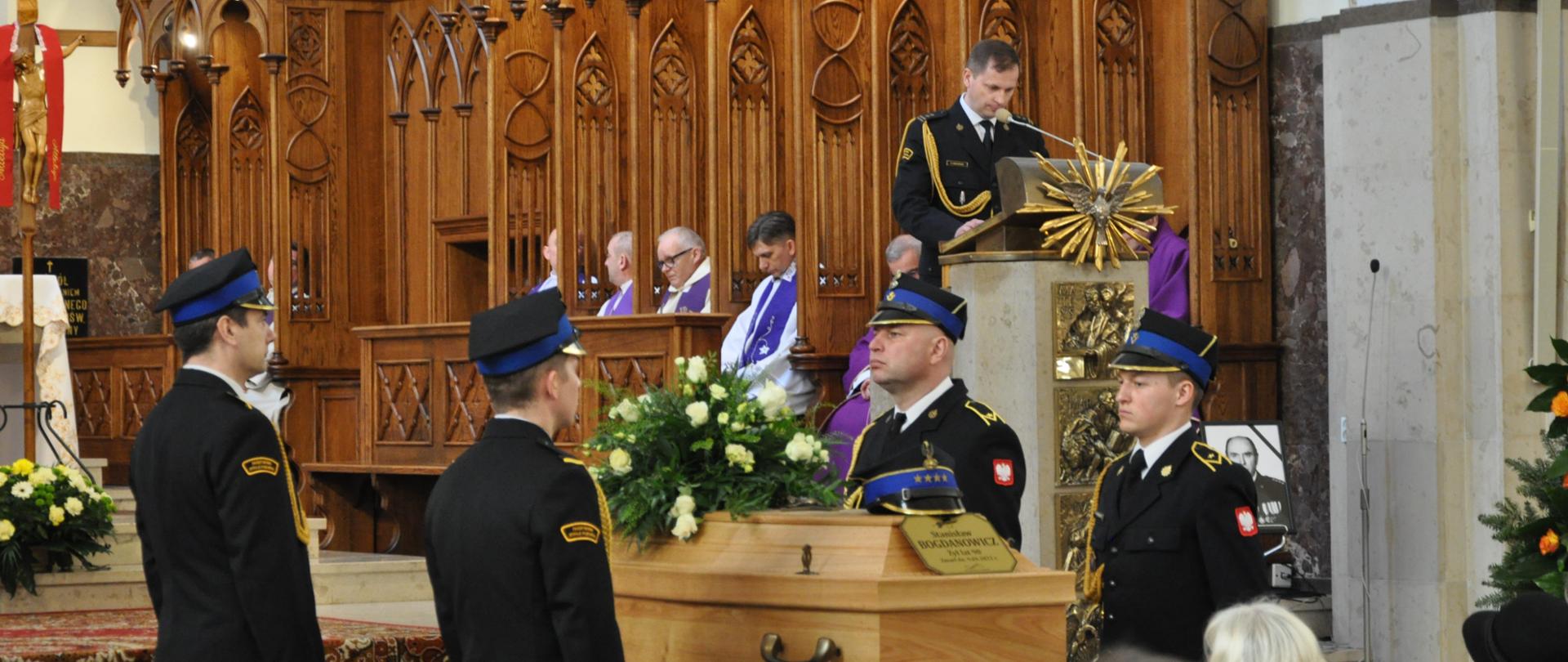 Uroczystości pogrzebowe śp. st. kpt w st. spocz. Stanisława Bogdanowicza - na zdjęciu w kościele komendant wygłasza słowo boże, przy trumnie stoją strażacy