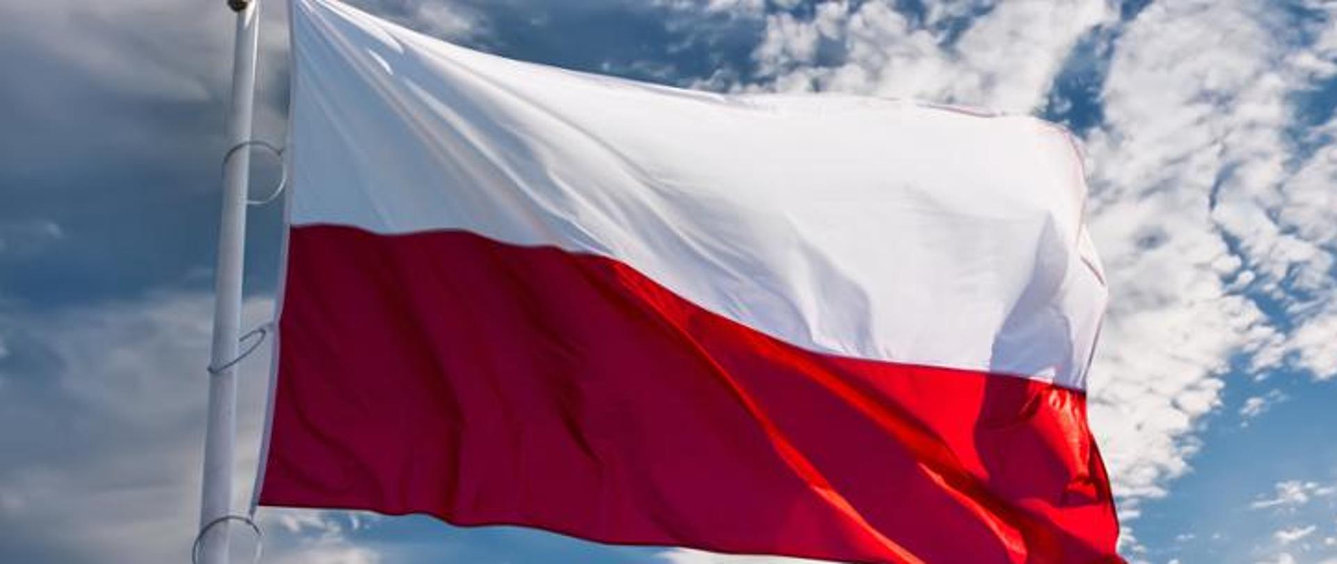 zdjęcie poglądowe - flaga Rzeczypospolitej Polskiej powiewająca na wietrze