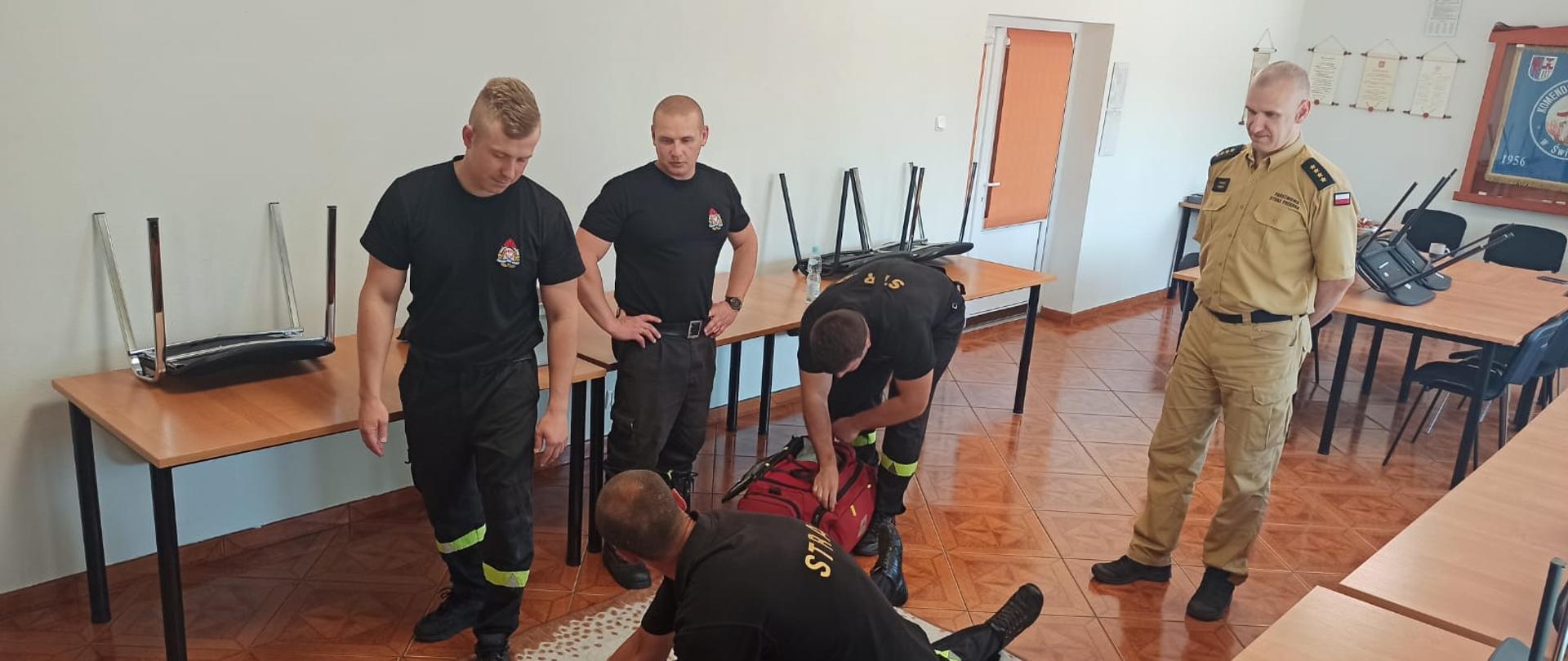 Zdjęcie przedstawia grupę strażaków podczas Recertyfikacja KPP w KP PSP Świdwin. Wykonują oni zadanie praktyczne.