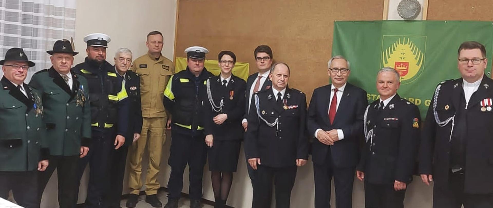 Zdjęcie pamiątkowe uczestników zebrania, w tle logo gminy.