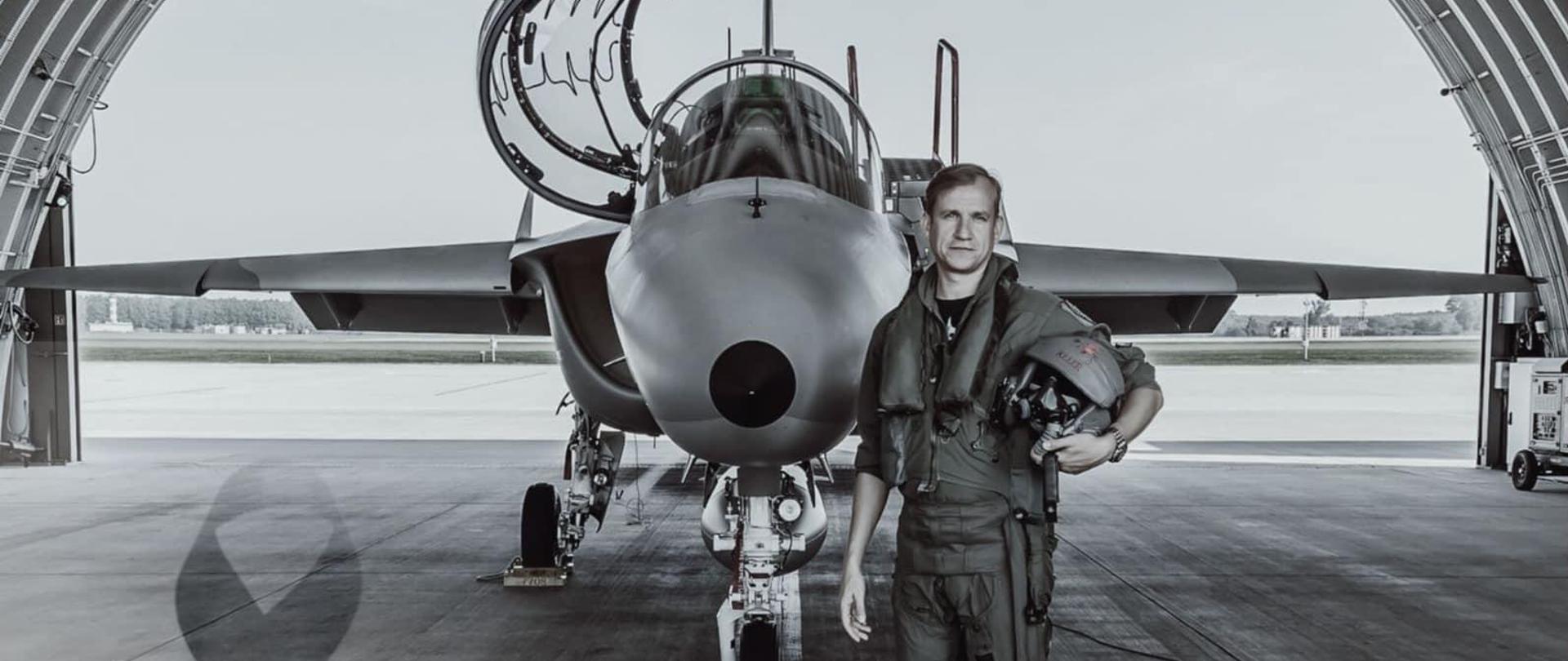 Na zdjęciu widnieje mężczyzna (pilot), w tle widać samolot.