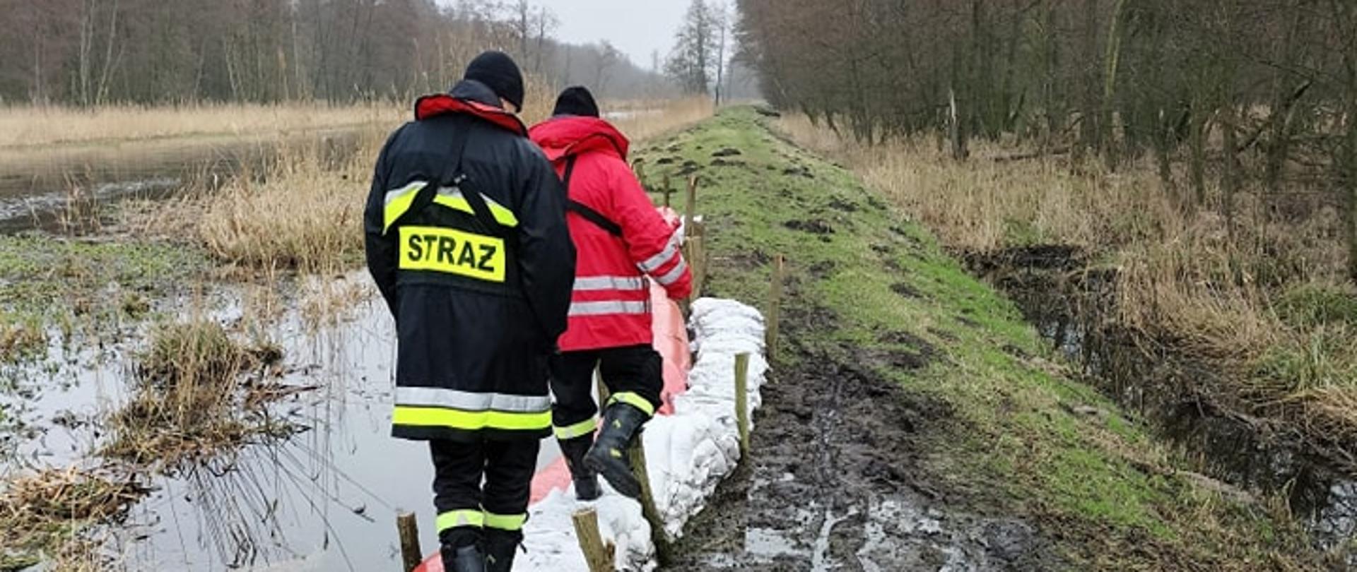 Strażacy monitorujący stan wałów przeciwpowodziowych