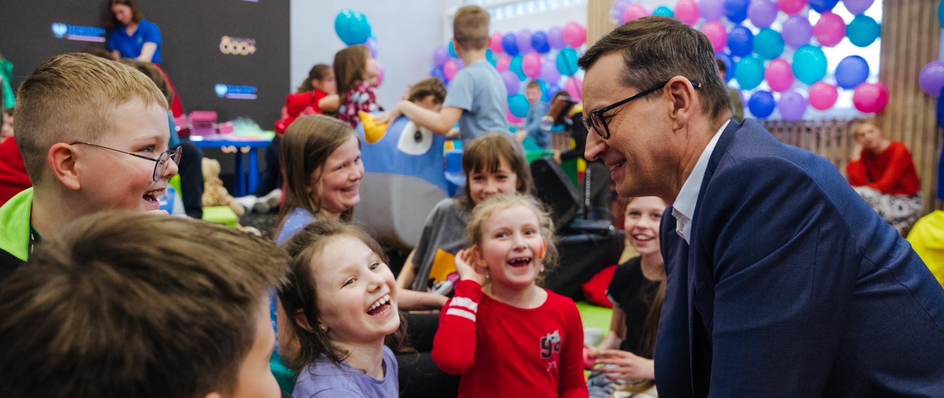 Premier rozmawia z dziećmi.