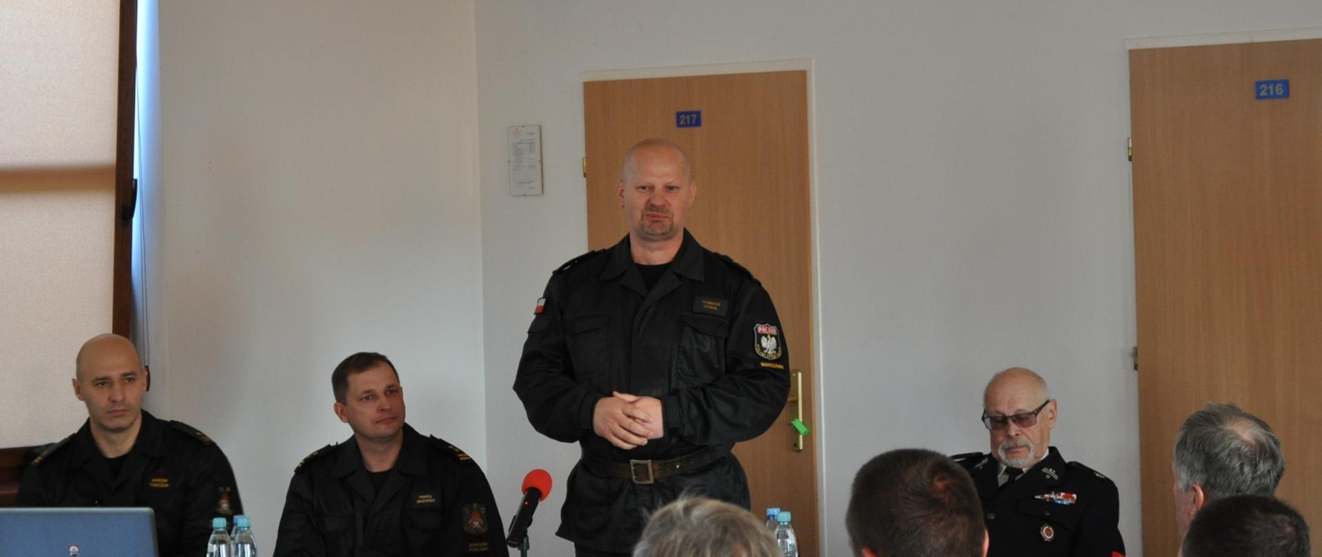 Spotkanie z przedstawicielami Ochotniczych Straży Pożarnych z terenu powiatu sokołowskiego - komendant wojewódzki przemawia, stoi za stołem prezydialnym. Na spotkanie zaproszeni zostali Prezesi, Naczelnicy z każdej jednostki OSP, komendanci gminni OSP oraz przedstawiciele samorządu powiatowego i samorządów miejskich/gminnych.