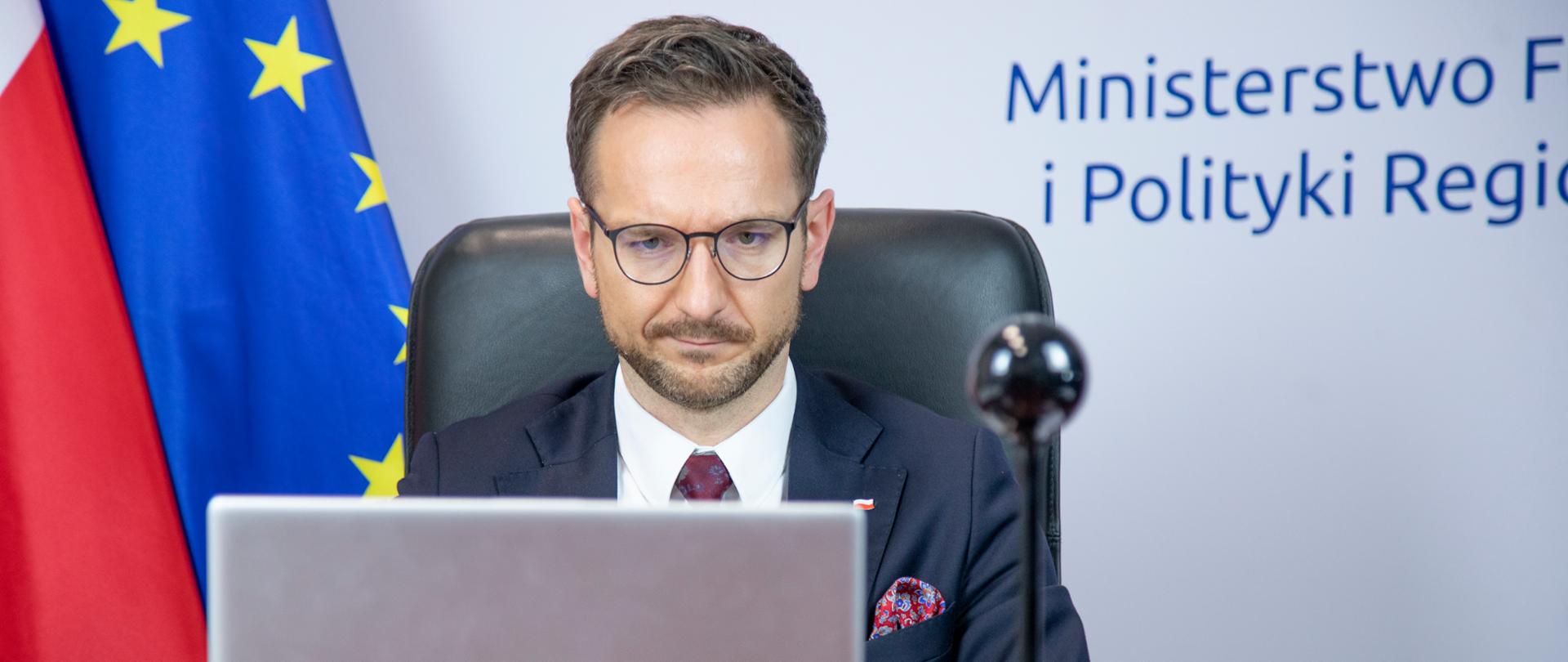 wiceminister Waldemar Buda przed komputerem uczestniczy w spotkaniu online