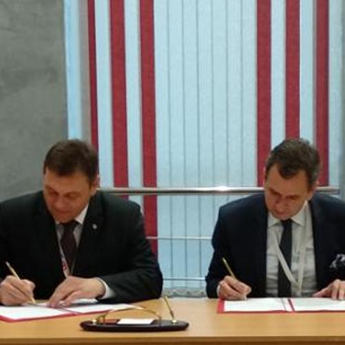 Two men are signing a document