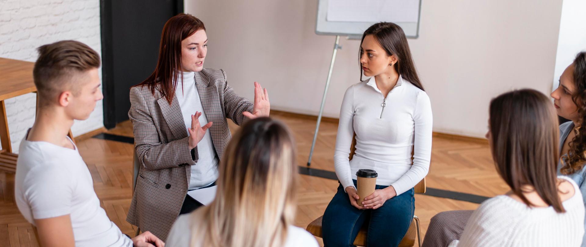 Ludzie siedzący w kręgu na krzesłach