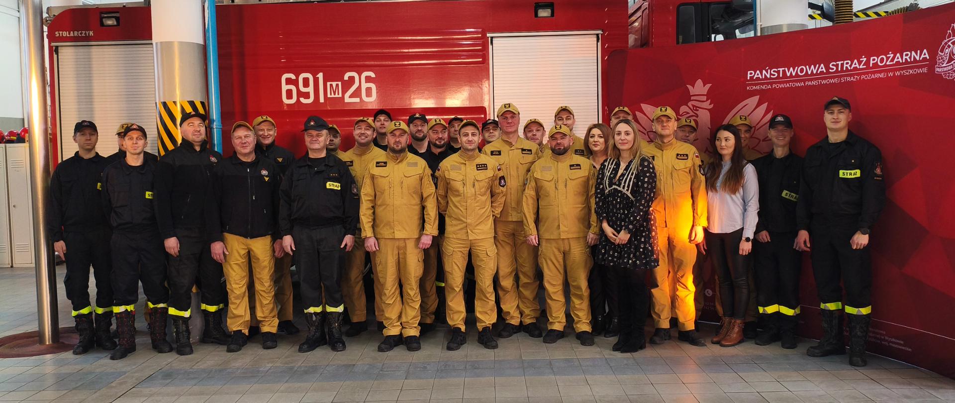 Pozowane grupowe zdjęcie uczestników uroczystej zbiórki na garażu JRG.