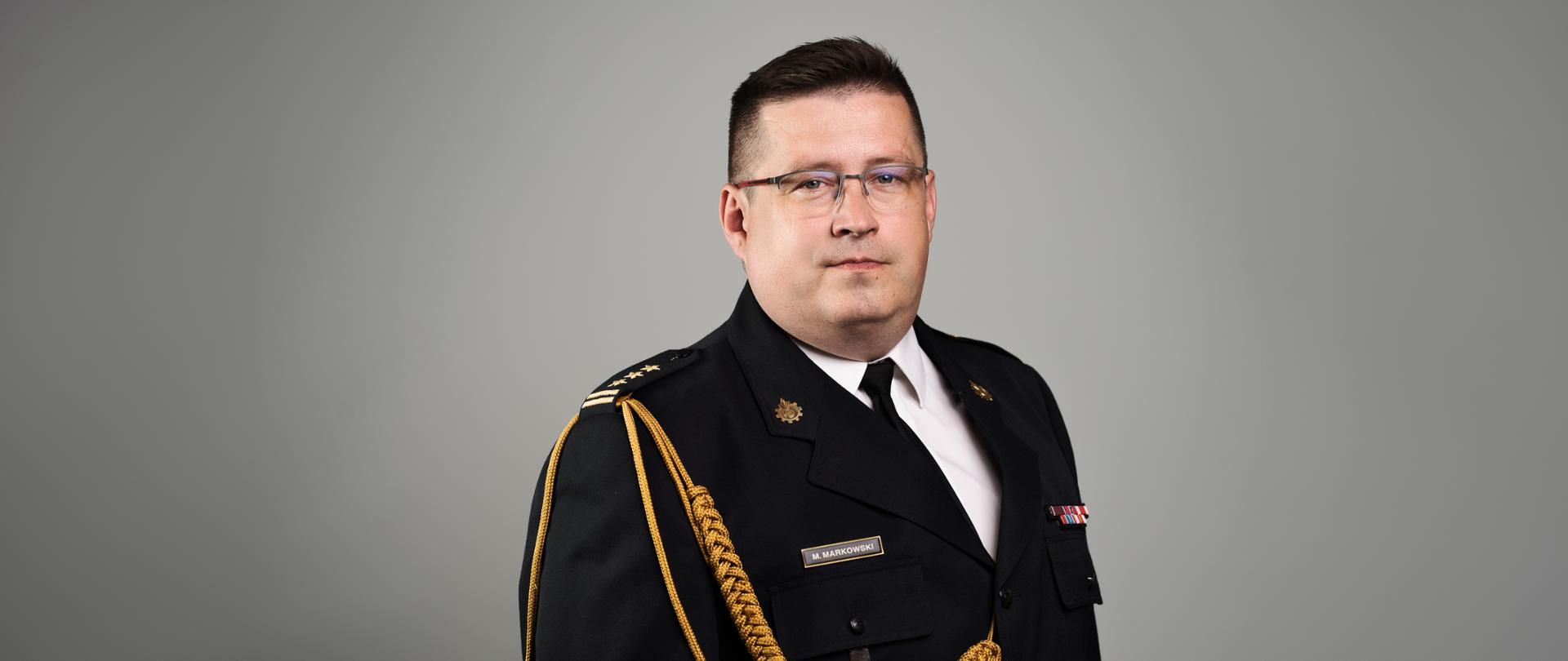 Zdjęcie przedstawia st. bryg. Marka Markowskiego pozującego do zdjęcia portretowego