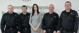Pani koordynator projektu wraz z czterema strażakami, stoi w szeregu pozując do zdjęcia