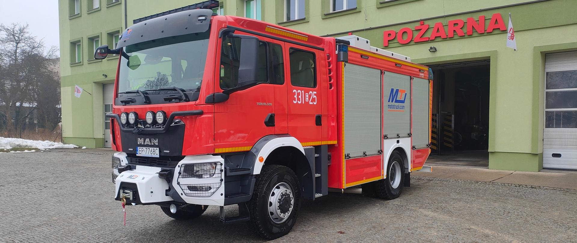 Samochód MAN TGM 18.320 na tle budynku KM PSP W Piotrkowie Tryb. 