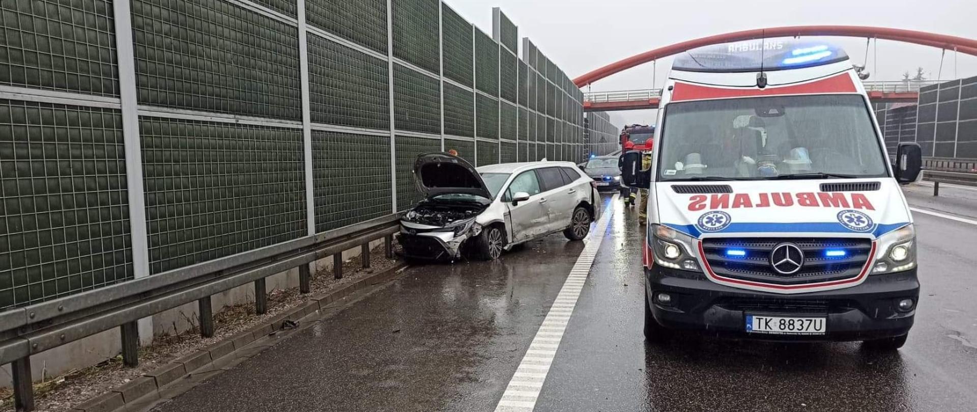 Na zdjęciu widzimy uszkodzony samochód osobowego marki Toyota Corolla, który uderzył w barierę energochłonną na trasie S7. Z rozbitego samochodu na drogę wyciekły płyny eksploatacyjne. Na prawo od Toyoty widzimy pojazd Zespołu Pogotowia Ratunkowego.