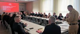 Zdjęcie przedstawia strażaków OSP oraz PSP w umundurowaniu wyjściowym podczas narady.