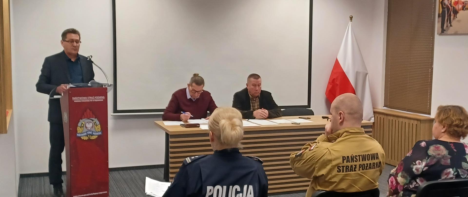Członkowie komisji siedzą na sali w KP PSP w Węgorzewie. 