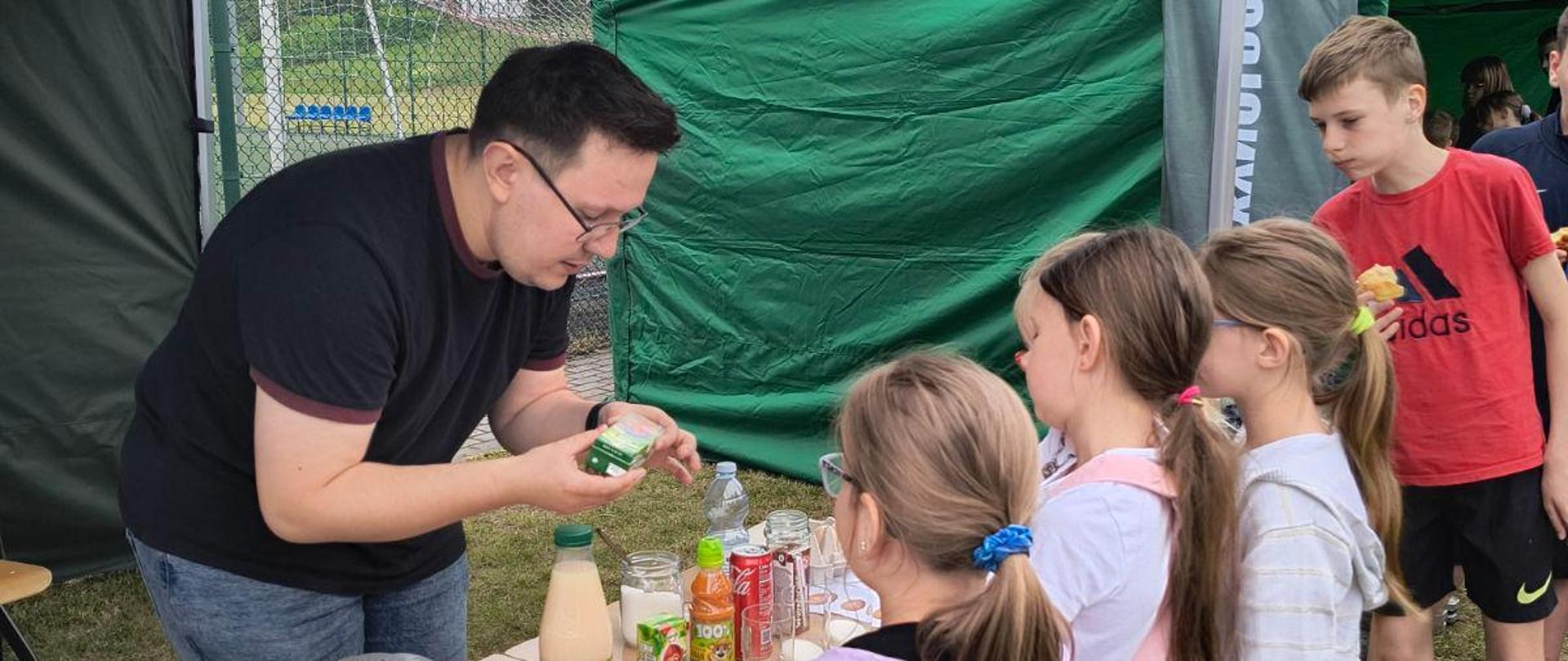 Pracownik WIJHARS prezentuje dzieciom ile cukru zawierają popularne napoje