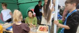 Dzieci przy stoisku uczestniczące w warsztatach