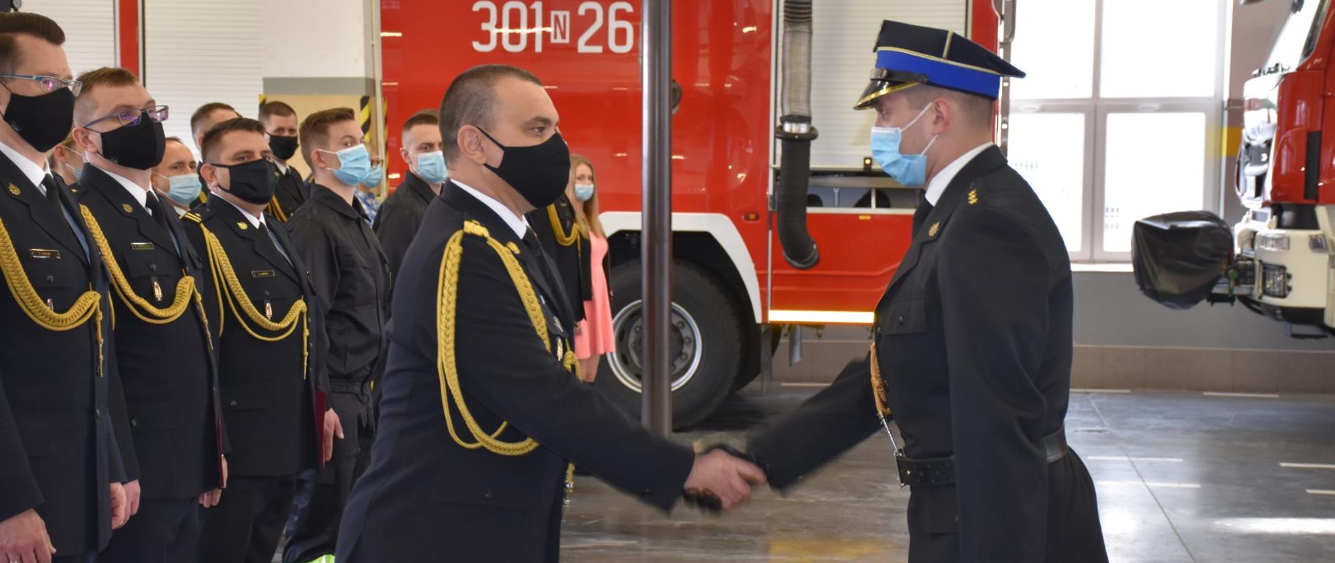 Zdjęcie przedstawia Warmińsko-Mazurskiego Komendanta Wojewódzkiego PSP w Olsztynie nadbryg. Tomasza Komoszyńskiego oraz Dowódcę uroczystości Kamila Kulasa składającego meldunek o zakończeniu uroczystości