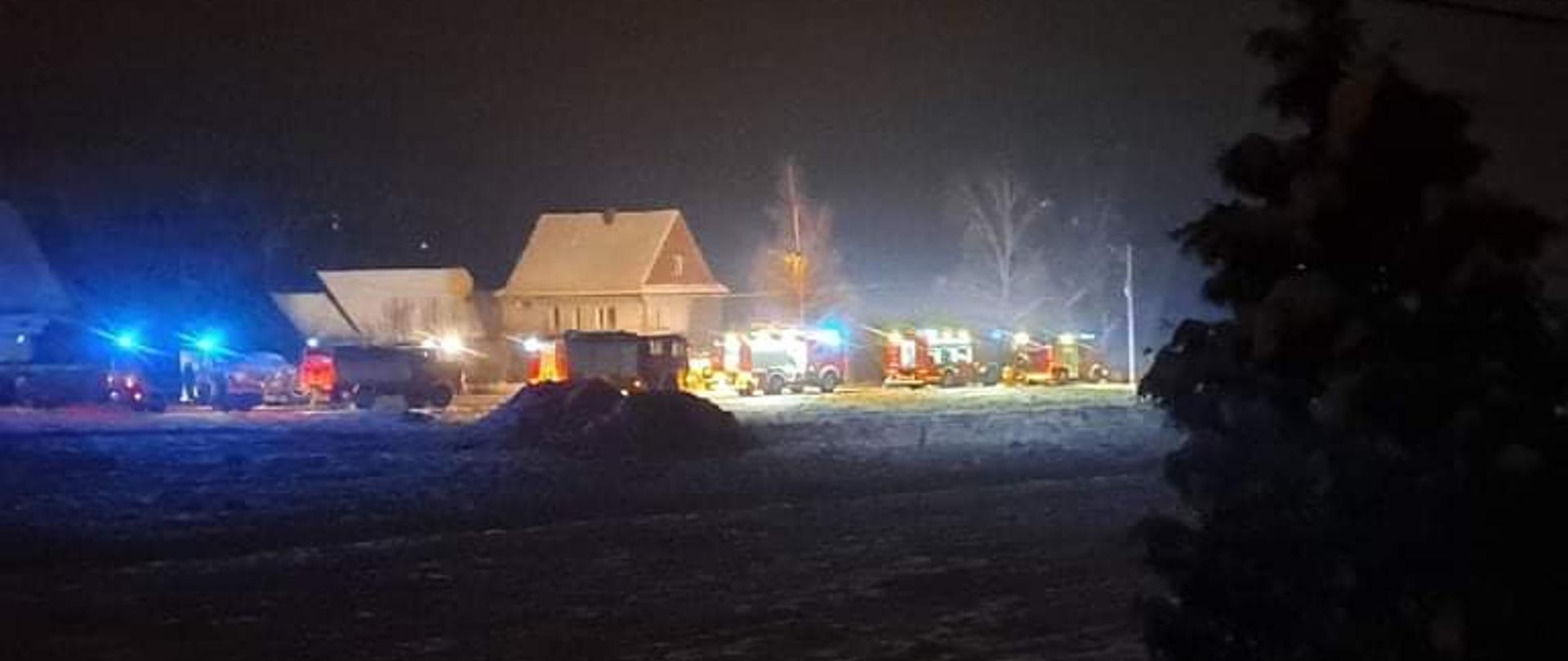 Zdjęcie przedstawia miejsce prowadzonych działań oświetlone przez samochody strażackie