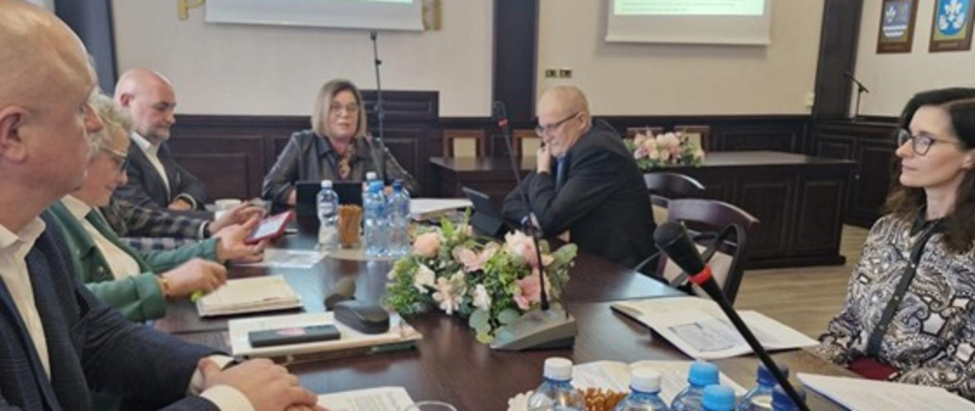 Na zdjęciu uczestnicy spotkania siedzący przy stole konferencyjnym