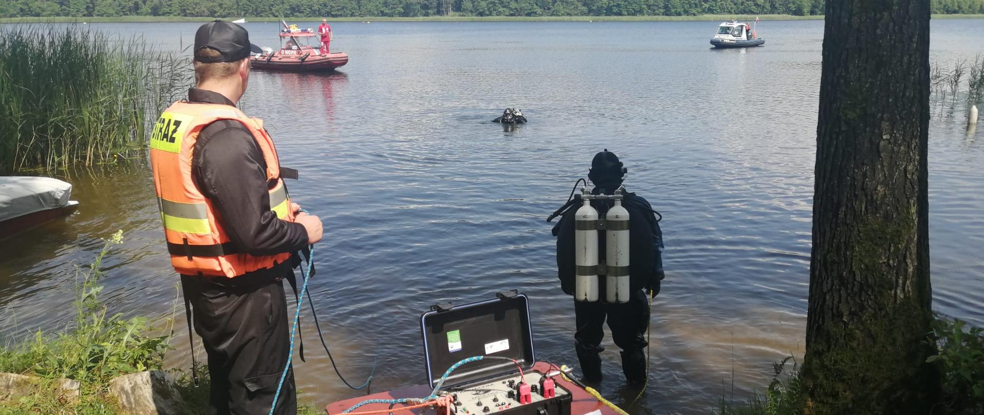 Na zdjęciu widać nurków, patrol policji oraz ratowników wopr.